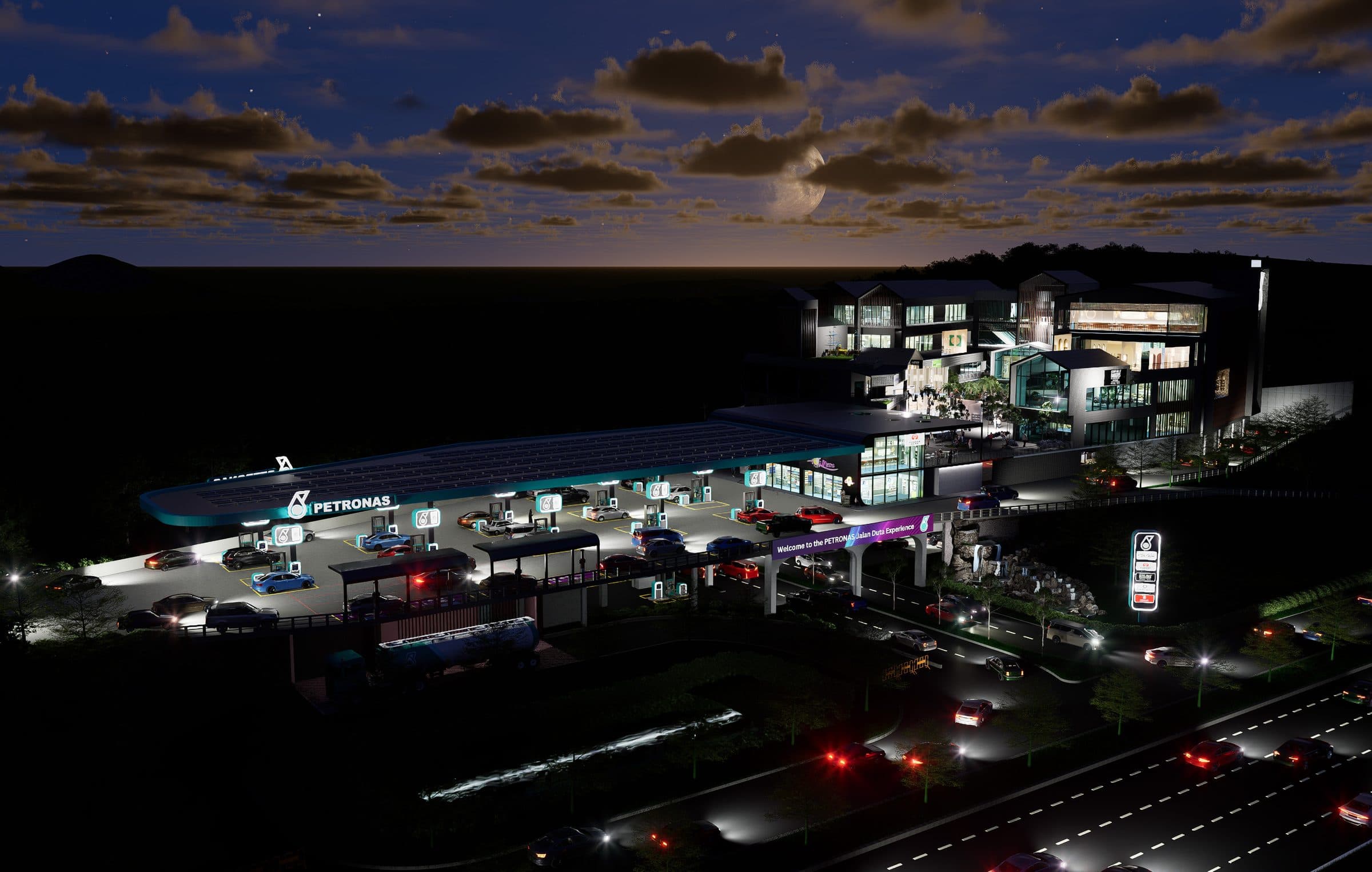 The station canopy and Lifestyle Complex illuminated at night, seen from the NKVE approach.
